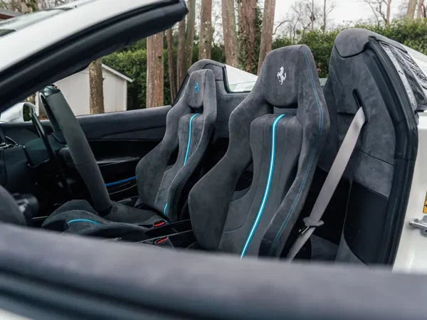 Dunkle Alcantara-Sportsitze mit türkisfarbenen Nähten in einem Ferrari